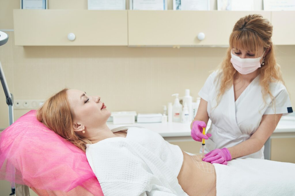 Beautiful female is receiving anti cellulite injection in beauty center